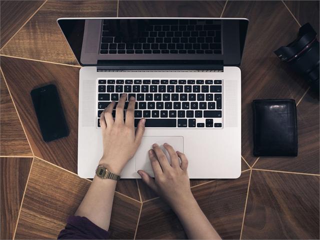Dłonie na klawiaturze laptopa, widok z góry